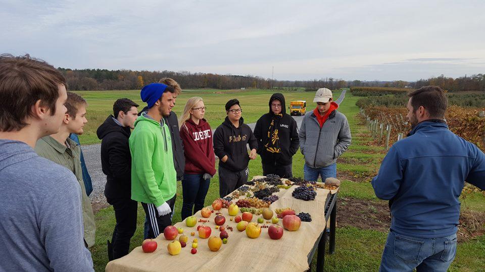 Students at agriculture research station with various fruit