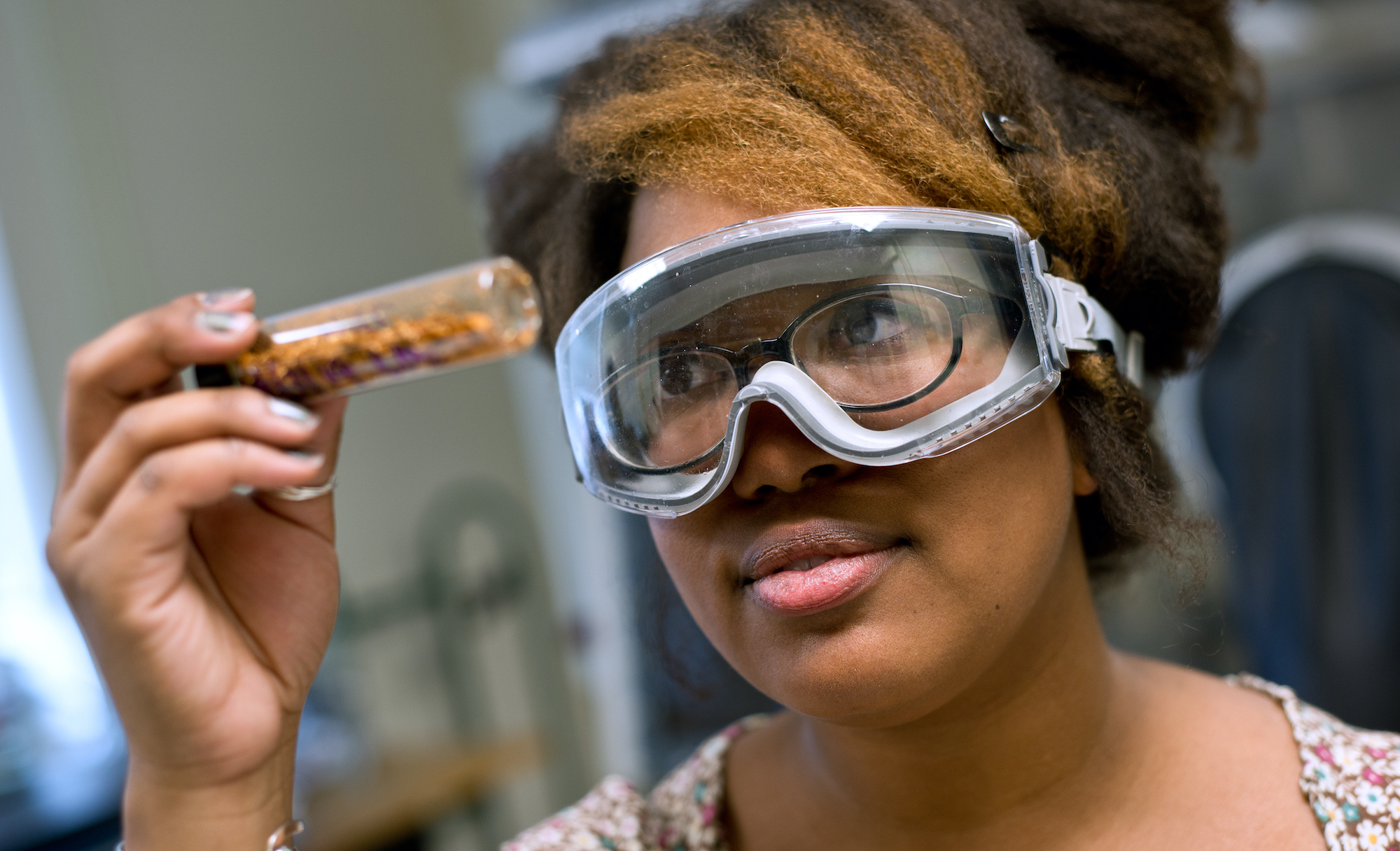 student with goggles looking at sample